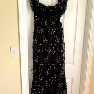 Crafted of lace, Shoshanna’s elegant dress with ruffle shoulder straps.